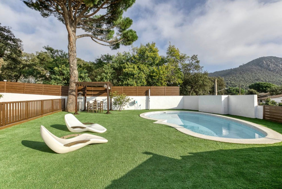 Piscina con jardín y montañas